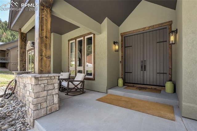 property entrance featuring stucco siding and covered porch