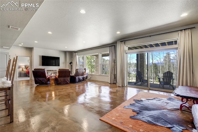living area with visible vents, recessed lighting, a textured ceiling, and finished concrete floors