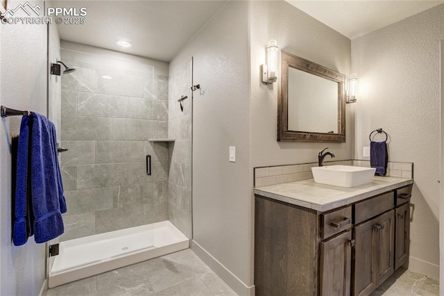 full bathroom with baseboards, a stall shower, and vanity