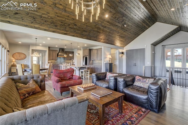 living room with high vaulted ceiling, recessed lighting, wood finished floors, and a chandelier