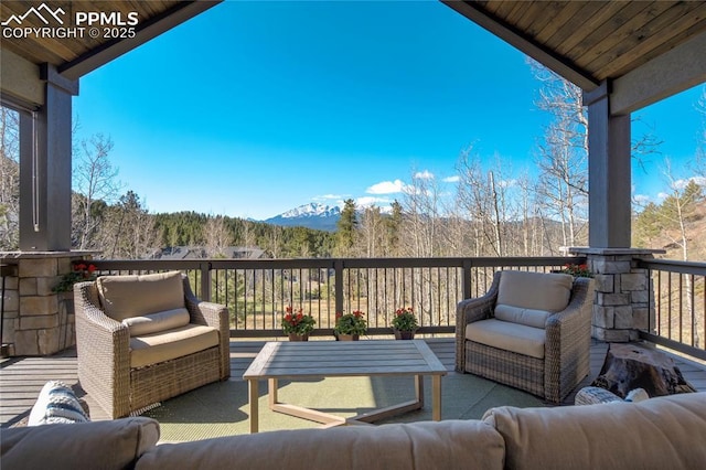 wooden terrace with an outdoor hangout area and a mountain view