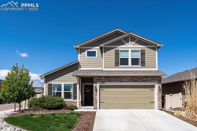 view of front of home with concrete driveway, an attached garage, fence, and stone siding