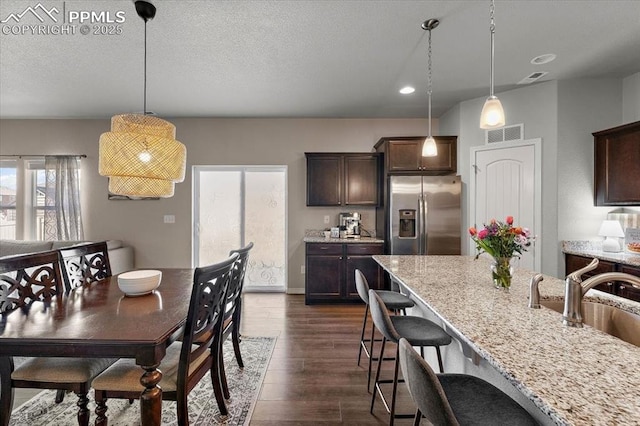 dining area with dark wood-type flooring and visible vents
