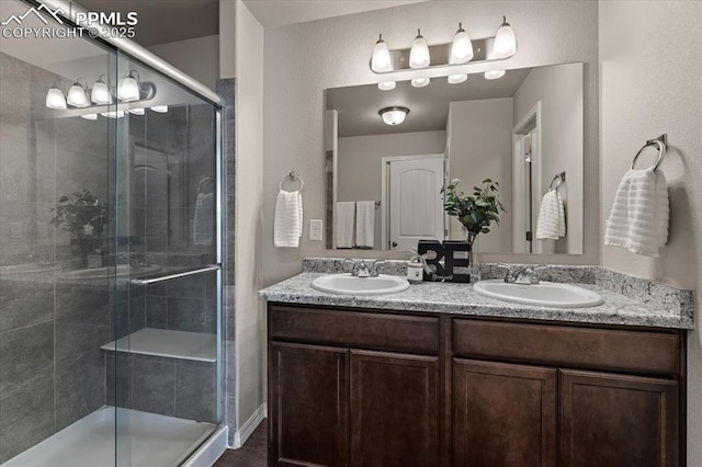 bathroom with double vanity, a sink, and a shower stall