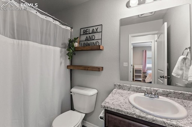 bathroom featuring vanity, toilet, and curtained shower