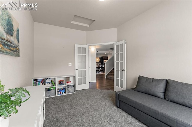 living area with french doors, carpet flooring, and attic access