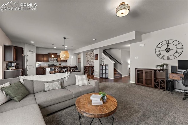 living area featuring recessed lighting, baseboards, stairs, and dark carpet
