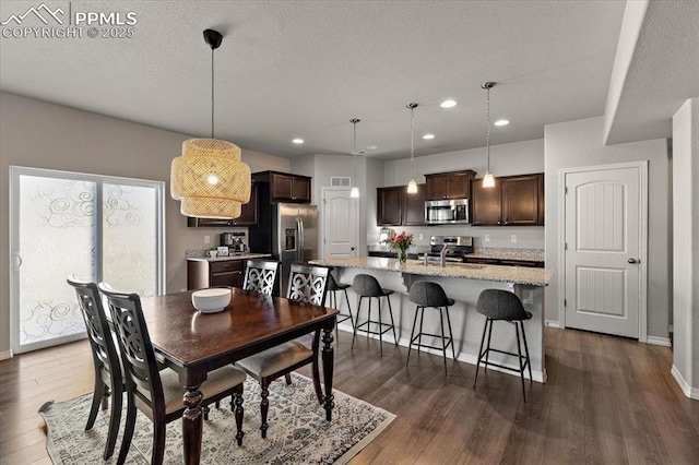 dining space with recessed lighting, baseboards, dark wood-style floors, and a textured ceiling