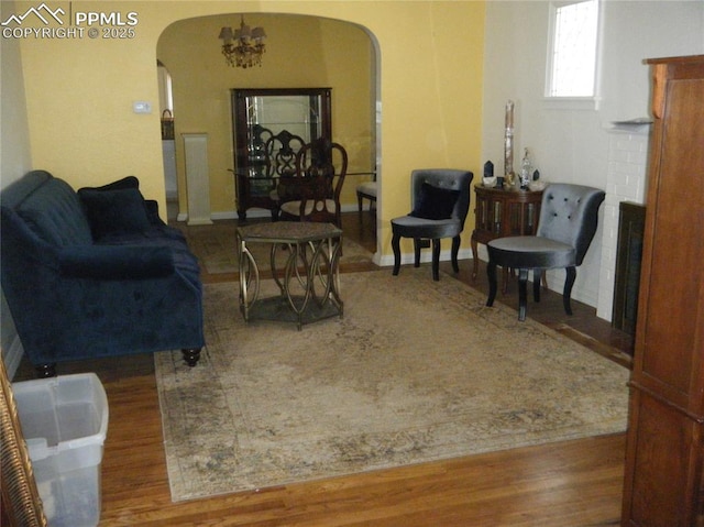415 Veta Ave, Pueblo, CO 81004 - living room featuring an inviting chandelier, arched walkways, baseboards, and wood finished floors
