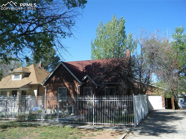 415 Veta Ave, Pueblo, CO 81004 - view of front of house with concrete driveway, brick siding, a chimney, and fence private yard
