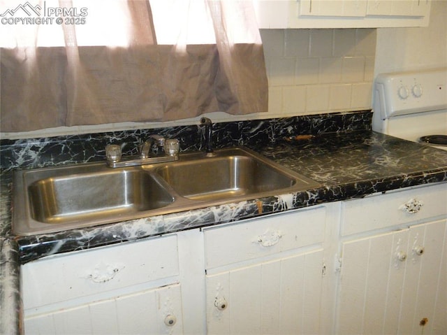 415 Veta Ave, Pueblo, CO 81004 - kitchen with a sink, tasteful backsplash, white range oven, and white cabinetry