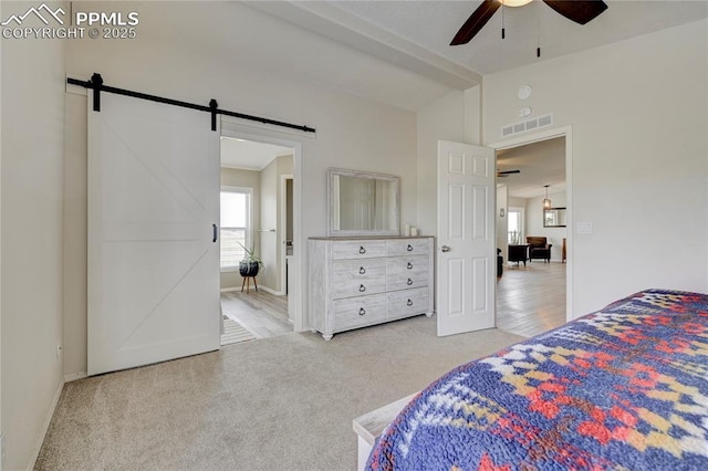 bedroom featuring a barn door, carpet, baseboards, vaulted ceiling with beams, and visible vents