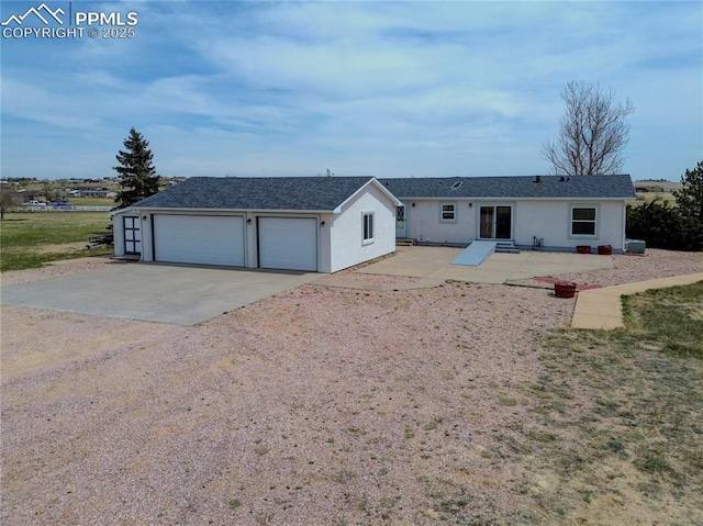 view of front of property with dirt driveway, a patio area, and stucco siding