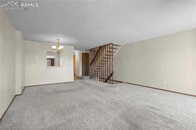 unfurnished living room with an inviting chandelier, baseboards, stairway, a textured ceiling, and carpet