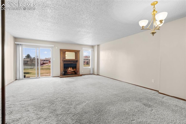 unfurnished living room featuring carpet flooring, a textured ceiling, a brick fireplace, and a chandelier