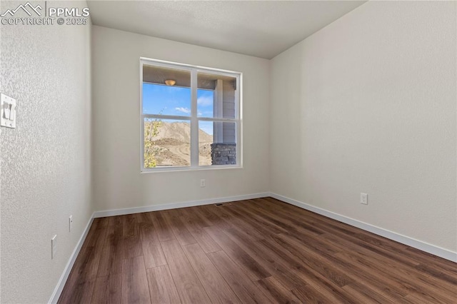 9803 Blaurock Dr, Fountain, CO 80817 - spare room featuring baseboards, visible vents, and dark wood-type flooring