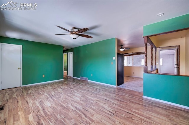 empty room featuring baseboards, ceiling fan, wood finished floors, and visible vents