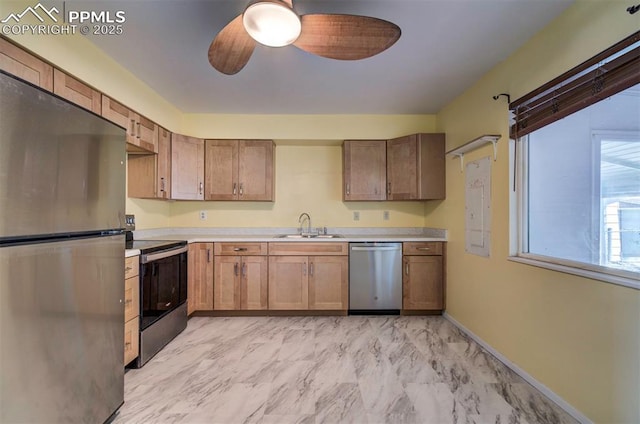 kitchen with marble finish floor, ceiling fan, light countertops, a sink, and stainless steel appliances