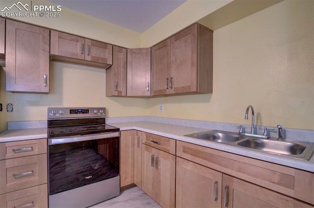 kitchen featuring light countertops, stainless steel electric range, a sink, and marble finish floor