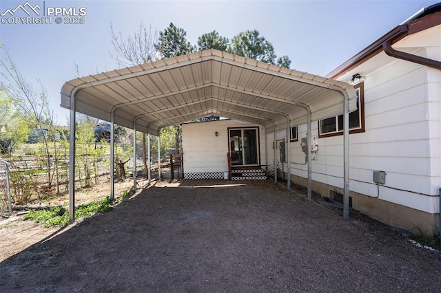 view of vehicle parking with fence and a carport