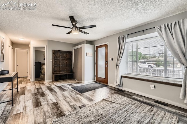 entrance foyer with a textured ceiling, wood finished floors, baseboards, and ceiling fan