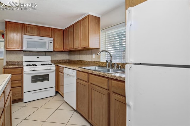 kitchen featuring a sink, brown cabinets, white appliances, and light tile patterned flooring