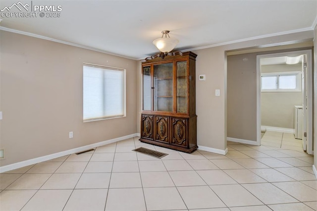 unfurnished dining area featuring crown molding, baseboards, light tile patterned floors, and visible vents