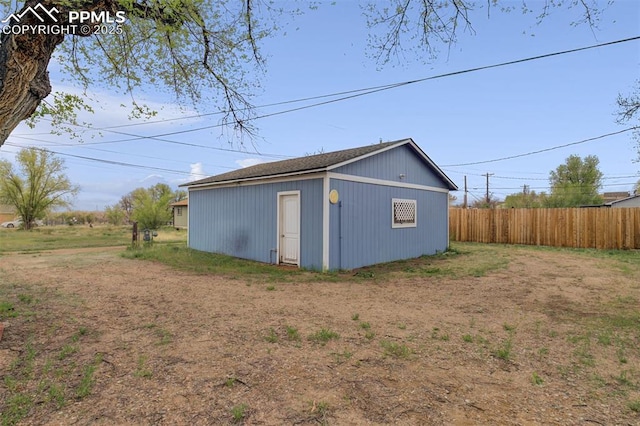 view of outbuilding with fence and an outbuilding