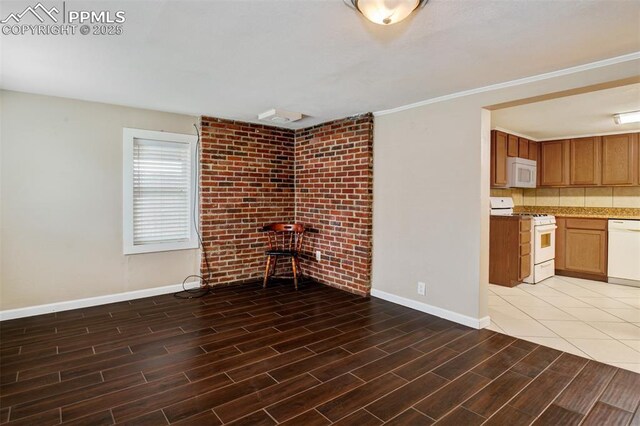 unfurnished living room featuring baseboards, brick wall, and wood tiled floor