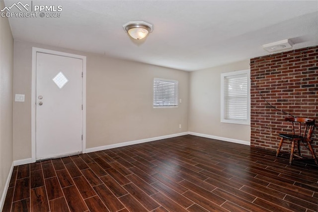 foyer with baseboards, a wealth of natural light, and wood finished floors