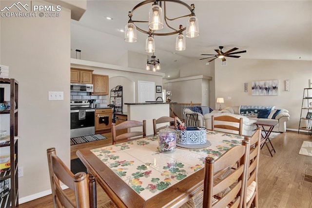 dining area with light wood-style floors, baseboards, and ceiling fan with notable chandelier