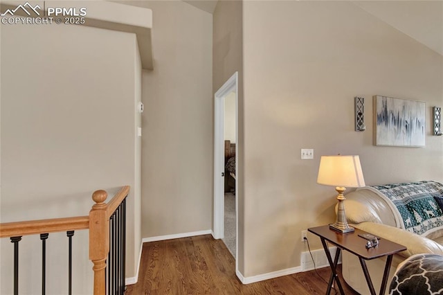 corridor featuring baseboards and wood finished floors