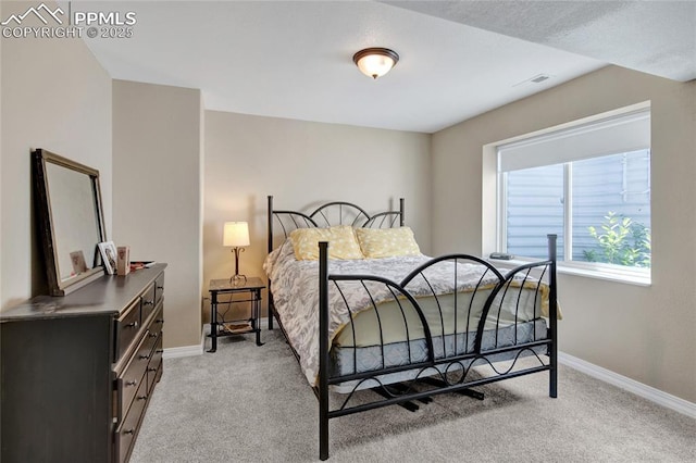 bedroom with baseboards, light colored carpet, and visible vents