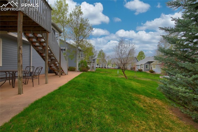 view of yard with a residential view, stairs, and a patio area