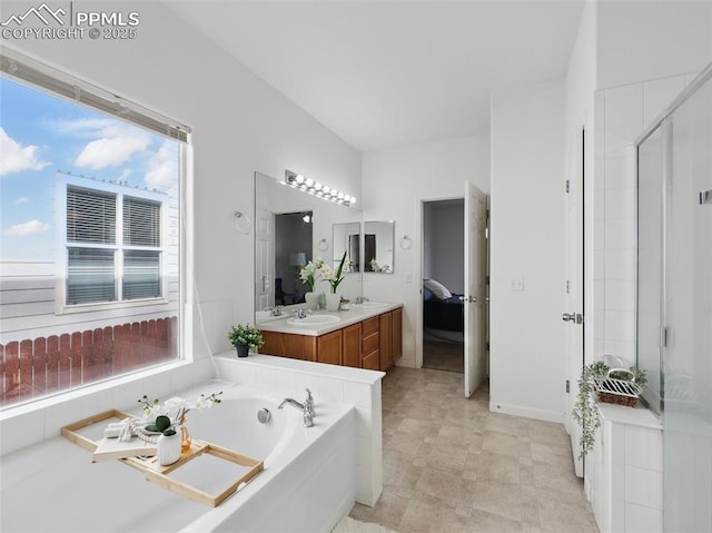 bathroom with double vanity, a sink, a garden tub, and a stall shower
