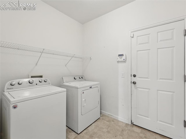 washroom with laundry area, baseboards, and washing machine and clothes dryer
