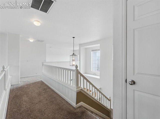 stairs featuring carpet flooring, baseboards, visible vents, and an inviting chandelier