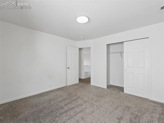 unfurnished bedroom featuring baseboards, carpet, and a closet
