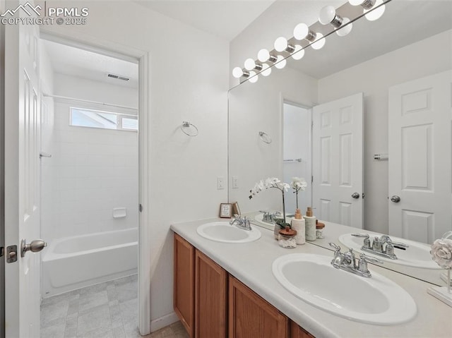bathroom with double vanity, visible vents, and a sink
