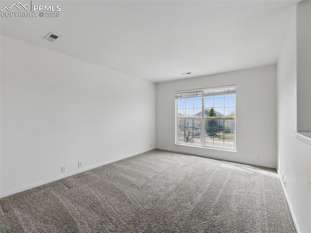 carpeted spare room featuring visible vents and baseboards