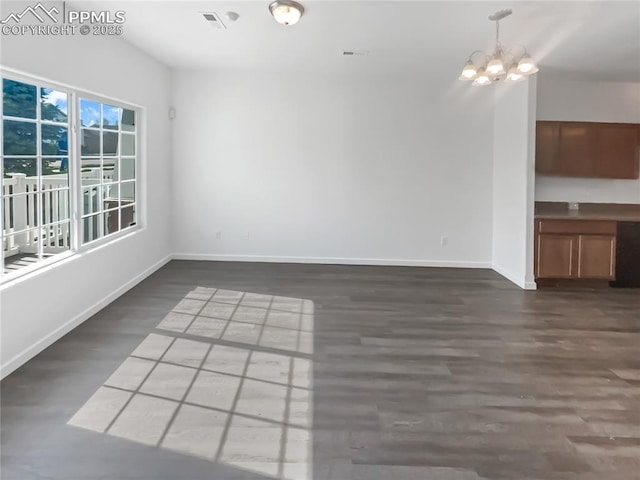 unfurnished dining area featuring baseboards, visible vents, dark wood-style floors, and a notable chandelier