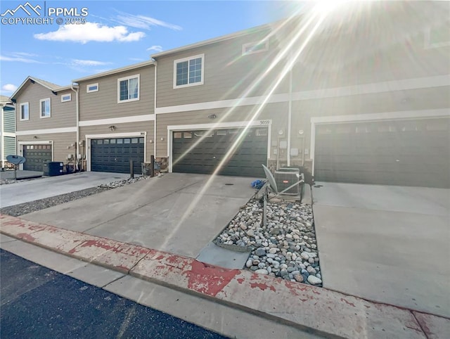 multi unit property featuring a garage and driveway