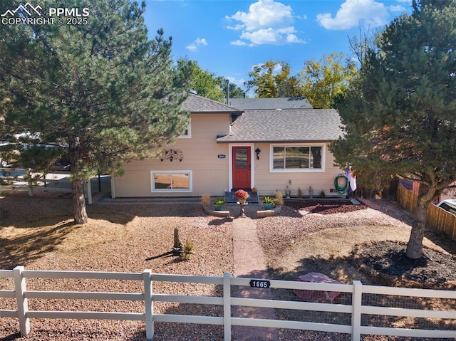 1065 N 19th St, Colorado Springs, CO 80904 - tri-level home with roof with shingles and a fenced front yard