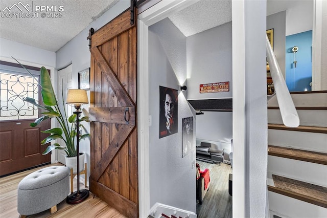 1065 N 19th St, Colorado Springs, CO 80904 - stairs with a textured ceiling, a barn door, and wood finished floors