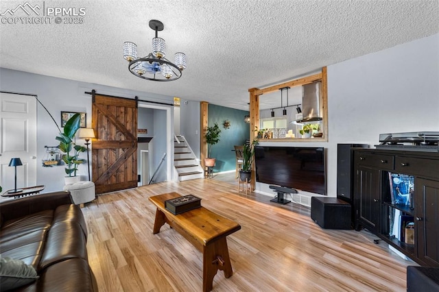 1065 N 19th St, Colorado Springs, CO 80904 - living room featuring a textured ceiling, an inviting chandelier, a barn door, and wood finished floors