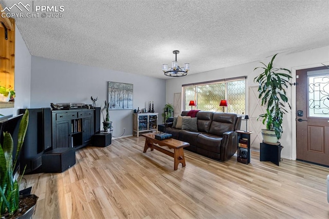 1065 N 19th St, Colorado Springs, CO 80904 - living area with a textured ceiling, a notable chandelier, and light wood finished floors