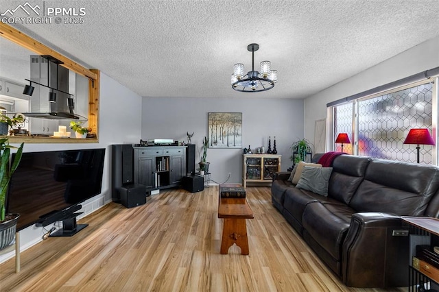 1065 N 19th St, Colorado Springs, CO 80904 - living area featuring an inviting chandelier, a textured ceiling, and light wood-style flooring