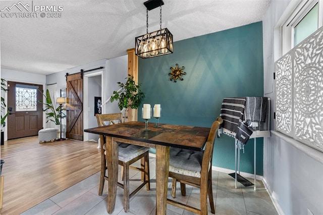 1065 N 19th St, Colorado Springs, CO 80904 - dining room featuring a textured ceiling, tile patterned flooring, a barn door, and a chandelier