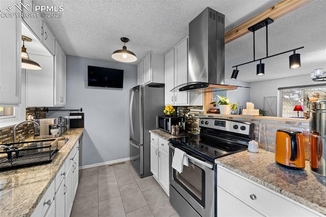 1065 N 19th St, Colorado Springs, CO 80904 - kitchen featuring a textured ceiling, white cabinets, island exhaust hood, appliances with stainless steel finishes, and backsplash