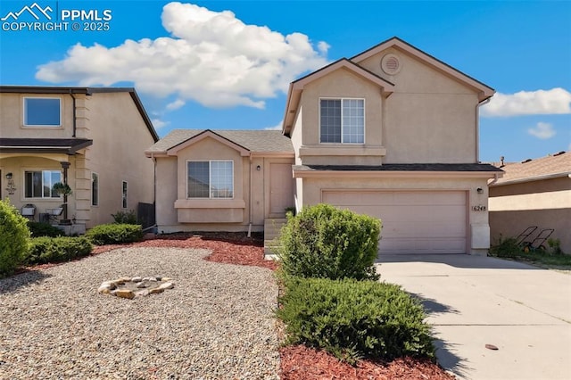traditional-style home with a garage, stucco siding, and driveway